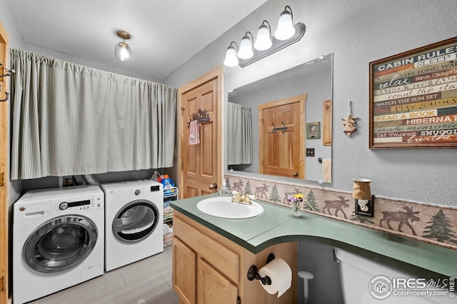 bathroom with washer and clothes dryer, vanity, and a textured wall