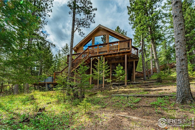 rear view of house with stairs and a deck