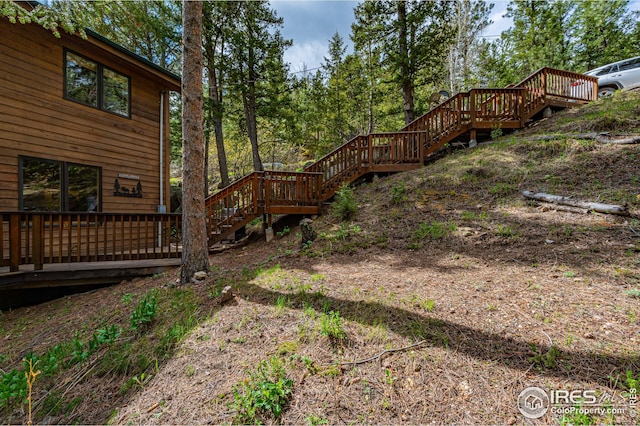 view of yard featuring a deck and stairs
