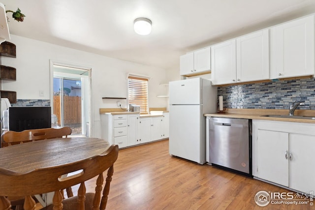 kitchen featuring stainless steel dishwasher, white cabinetry, white fridge, and light hardwood / wood-style flooring