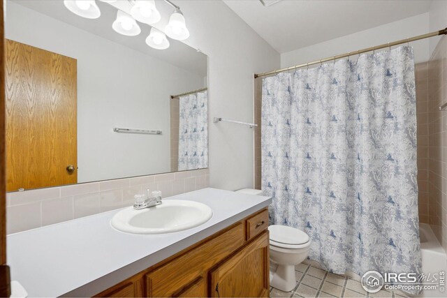 bathroom with vanity, tile patterned flooring, toilet, and decorative backsplash