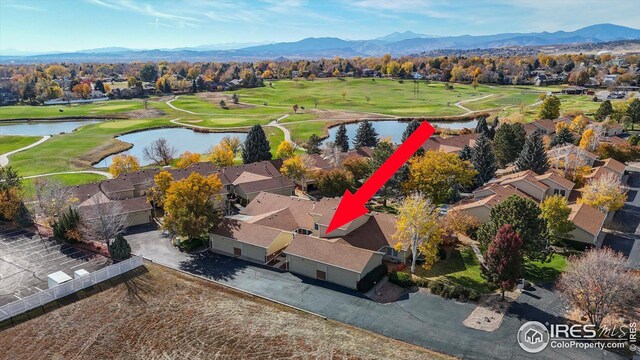 drone / aerial view with golf course view, a residential view, and a water and mountain view