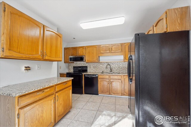 kitchen featuring a sink, backsplash, black appliances, and light tile patterned floors