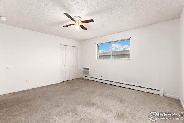 unfurnished bedroom with light carpet, ceiling fan, baseboard heating, a textured ceiling, and a closet