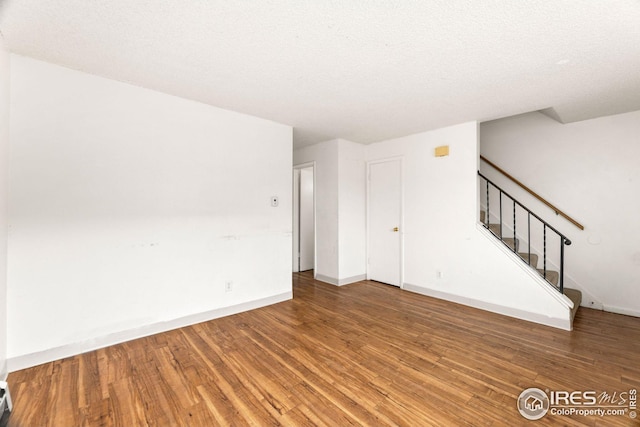 unfurnished room featuring a textured ceiling and hardwood / wood-style flooring