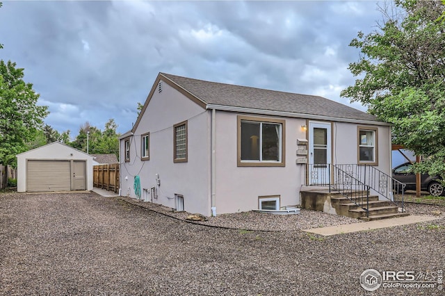1127 W Mulberry St, Fort Collins, CO 80521 - view of front facade with an outdoor structure, stucco siding, a garage, and a shingled roof