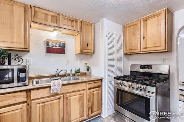 1127 W Mulberry St, Fort Collins, CO 80521 - kitchen with stainless steel appliances, light brown cabinets, a sink, a textured ceiling, and light countertops