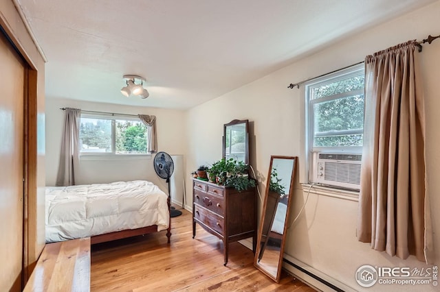 1127 W Mulberry St, Fort Collins, CO 80521 - bedroom with multiple windows, light wood finished floors, cooling unit, and a baseboard heating unit
