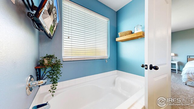 bathroom featuring a relaxing tiled tub