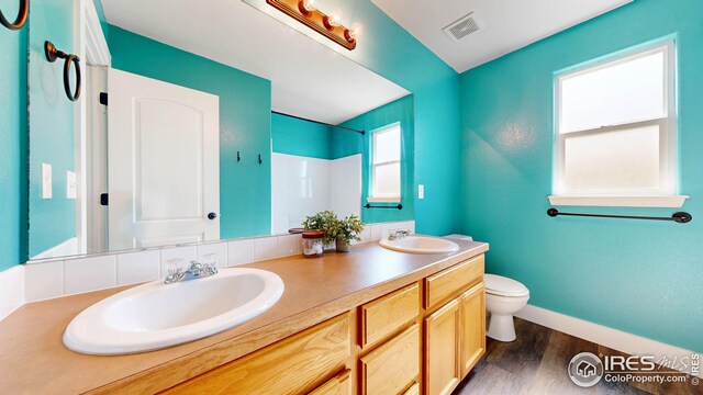 bathroom featuring wood-type flooring, toilet, and vanity