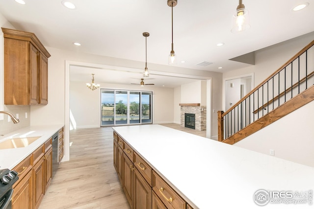 kitchen featuring brown cabinets, recessed lighting, appliances with stainless steel finishes, open floor plan, and a sink