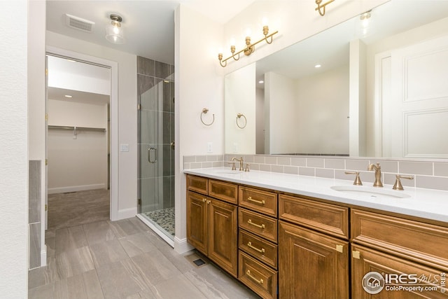 full bathroom with double vanity, a shower stall, visible vents, and a sink