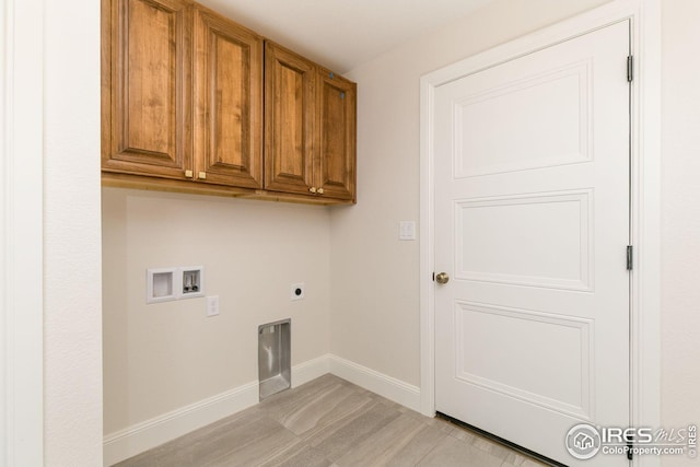 clothes washing area with baseboards, washer hookup, cabinet space, and electric dryer hookup