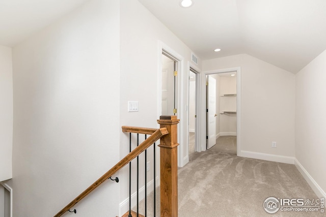 hall with visible vents, baseboards, light colored carpet, an upstairs landing, and recessed lighting