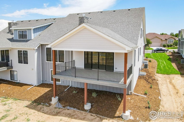 rear view of property with roof with shingles