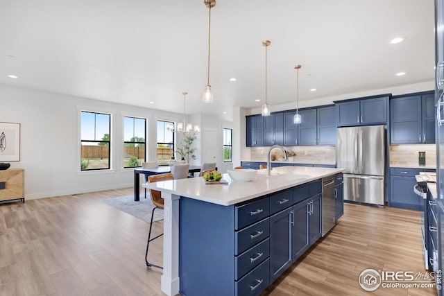 kitchen with appliances with stainless steel finishes, a sink, a breakfast bar, and decorative backsplash