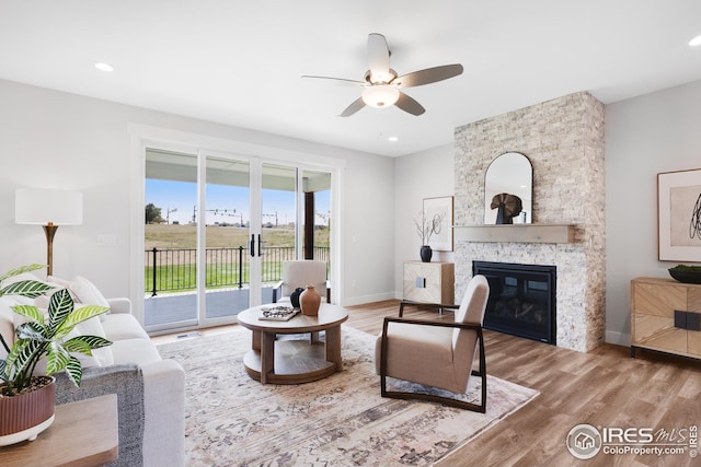 living area with recessed lighting, a fireplace, baseboards, and wood finished floors