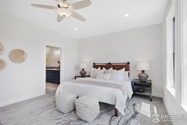 bedroom featuring recessed lighting, light colored carpet, ensuite bathroom, ceiling fan, and baseboards