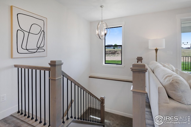 stairway with baseboards and a chandelier