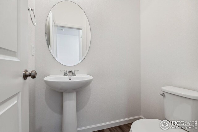 bathroom featuring wood-type flooring and toilet