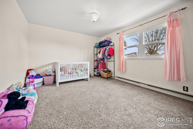 bedroom with carpet, baseboard heating, and a nursery area