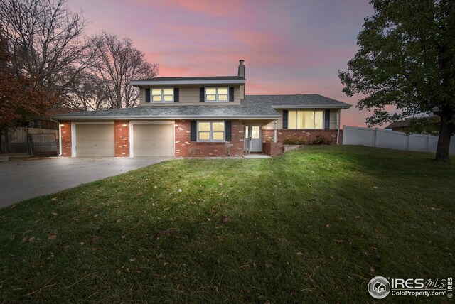 view of front of property with a garage and a yard