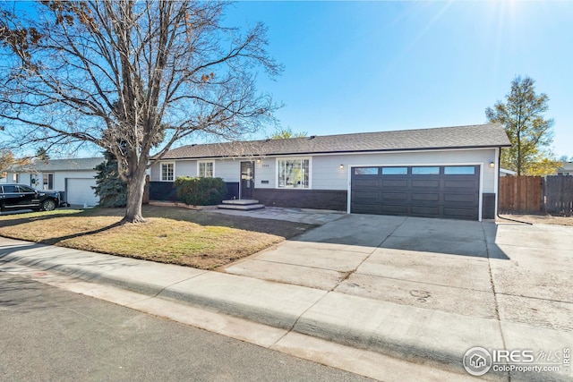 ranch-style home featuring a garage and a front lawn