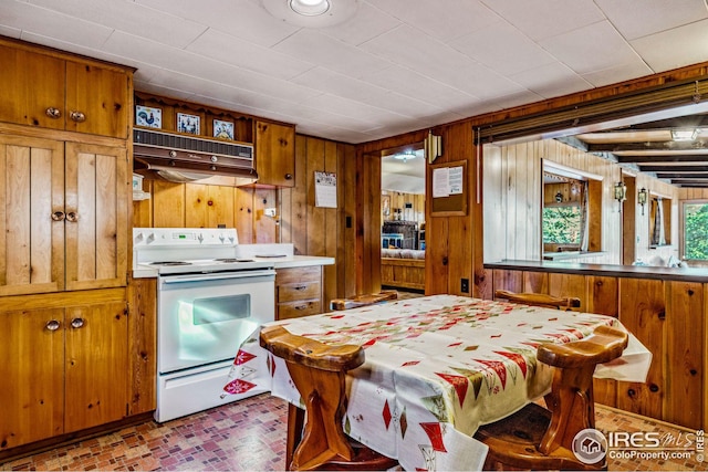 kitchen featuring white range with electric stovetop, wooden walls, and range hood