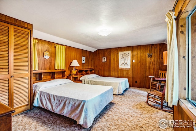 bedroom featuring wood walls, light colored carpet, a textured ceiling, and a closet