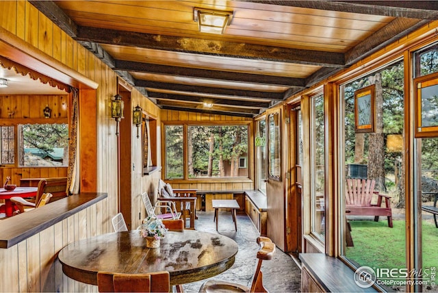 sunroom / solarium featuring wood ceiling, a wealth of natural light, and lofted ceiling with beams