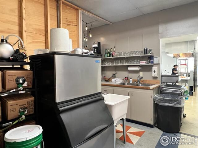 kitchen with white cabinets, refrigerator, and sink