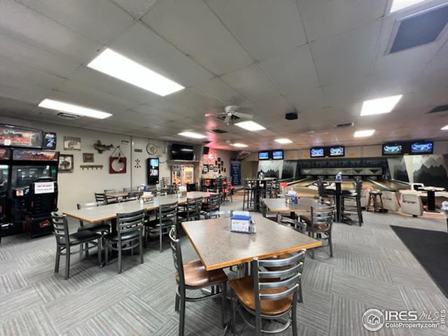 carpeted dining room with ceiling fan