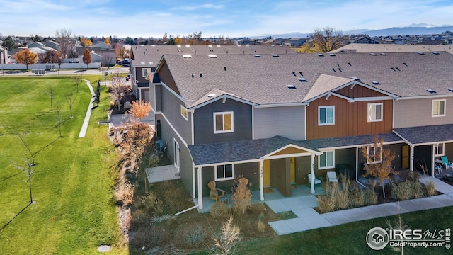 view of front of property featuring a mountain view, a front lawn, and a patio