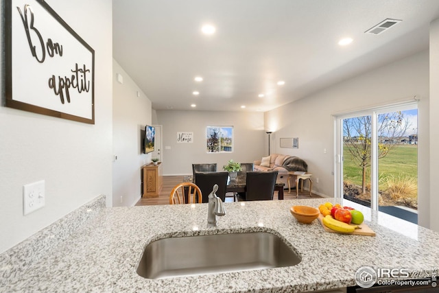 kitchen featuring light stone countertops and sink