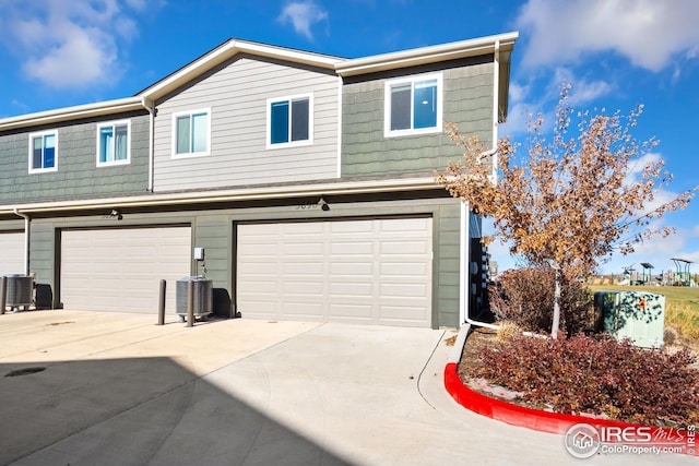 view of front of home featuring central AC unit and a garage