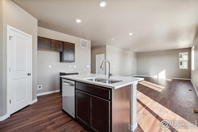 kitchen with dark brown cabinetry, sink, stainless steel dishwasher, dark hardwood / wood-style floors, and a kitchen island with sink