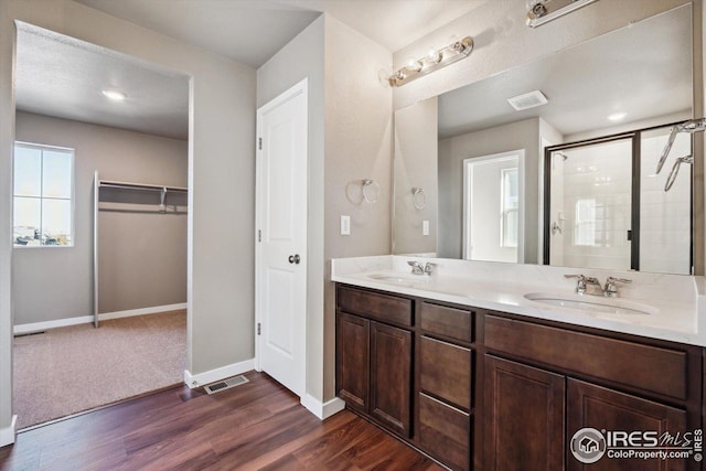 bathroom with hardwood / wood-style floors, vanity, and walk in shower