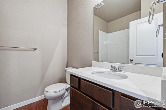 bathroom with hardwood / wood-style floors, vanity, and toilet