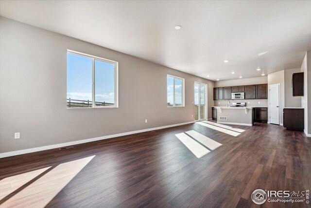 unfurnished living room featuring dark hardwood / wood-style flooring and sink