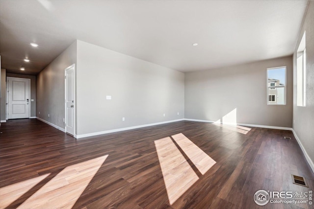 unfurnished room with dark wood-type flooring