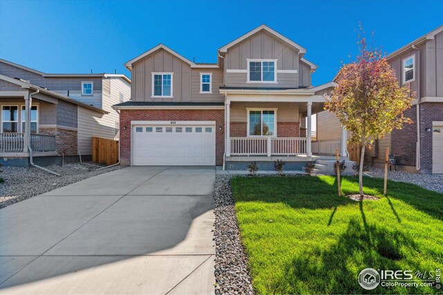 view of front of home featuring a garage, a porch, and a front yard