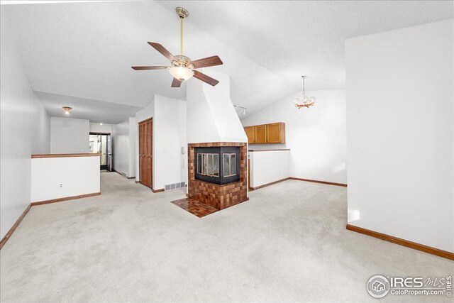 unfurnished living room with light carpet, a fireplace, vaulted ceiling, and ceiling fan