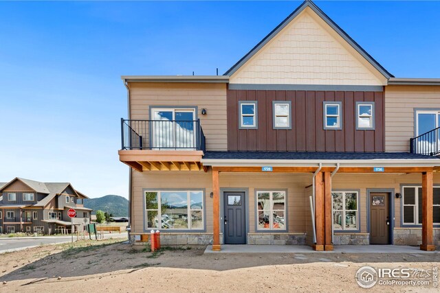 view of front of property featuring a mountain view and a balcony