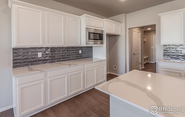 6105 Saddle Horn Dr, Timnath, CO 80547 - kitchen with stainless steel gas stove, decorative backsplash, white cabinetry, and light stone countertops