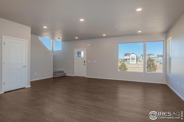 6105 Saddle Horn Dr, Timnath, CO 80547 - unfurnished living room with stairs, dark wood-style flooring, recessed lighting, and baseboards