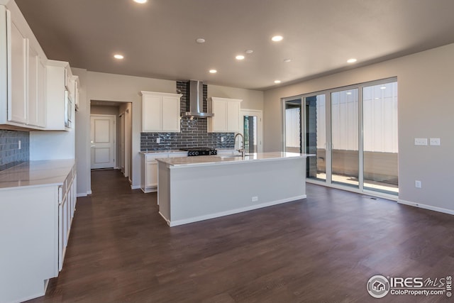 6105 Saddle Horn Dr, Timnath, CO 80547 - kitchen featuring wall chimney range hood, tasteful backsplash, a sink, dark wood-style flooring, and recessed lighting