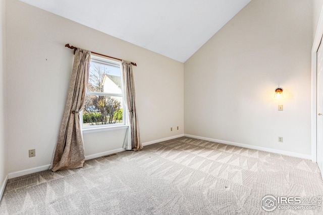 carpeted empty room with vaulted ceiling