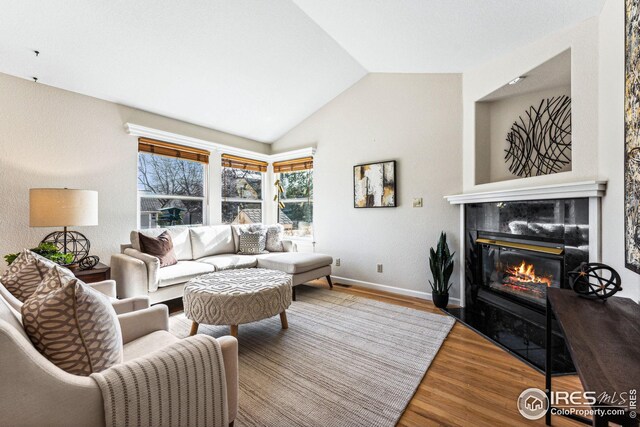 living room featuring hardwood / wood-style floors and vaulted ceiling