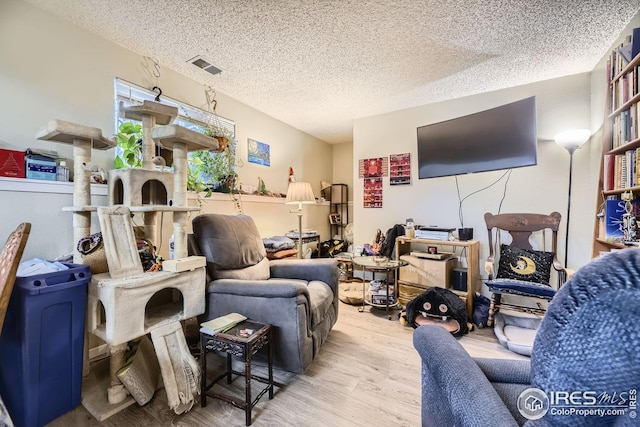 living room with a textured ceiling and light hardwood / wood-style floors