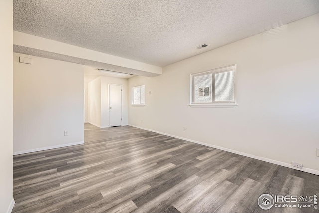 unfurnished room with dark hardwood / wood-style flooring and a textured ceiling